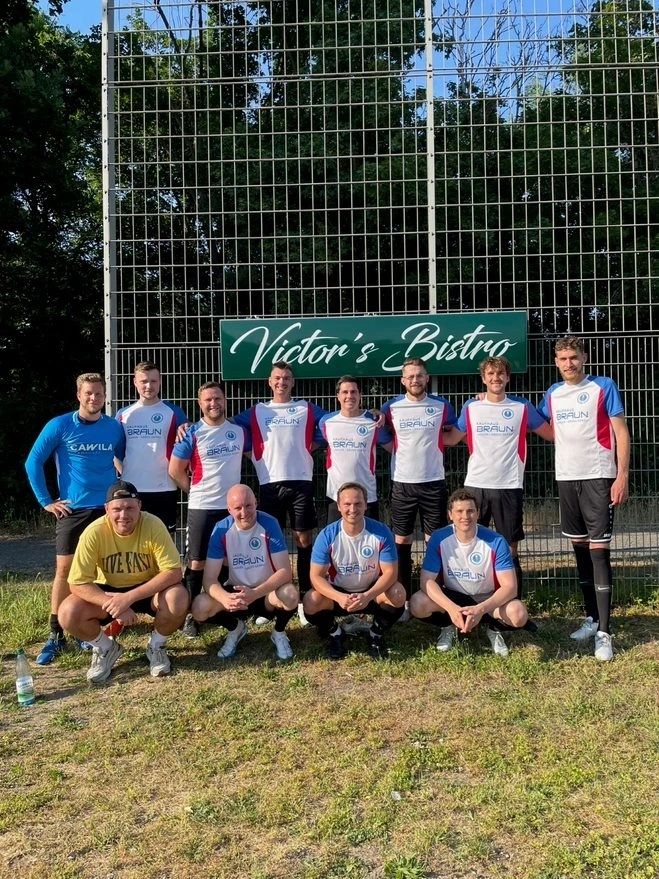 Teamfoto am Victor's-Bistro-Schild